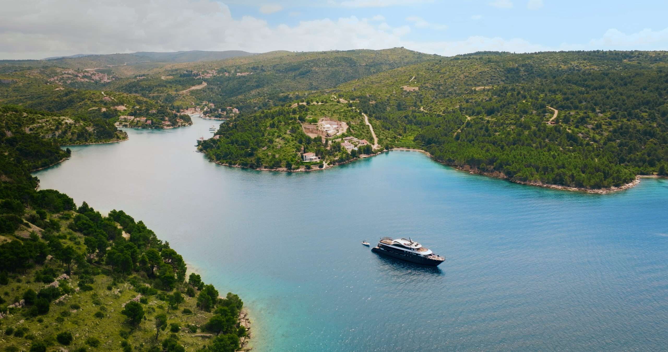 Aretha luxury yacht anchored in a secluded Croatian bay surrounded by pristine turquoise waters and lush island landscapes.