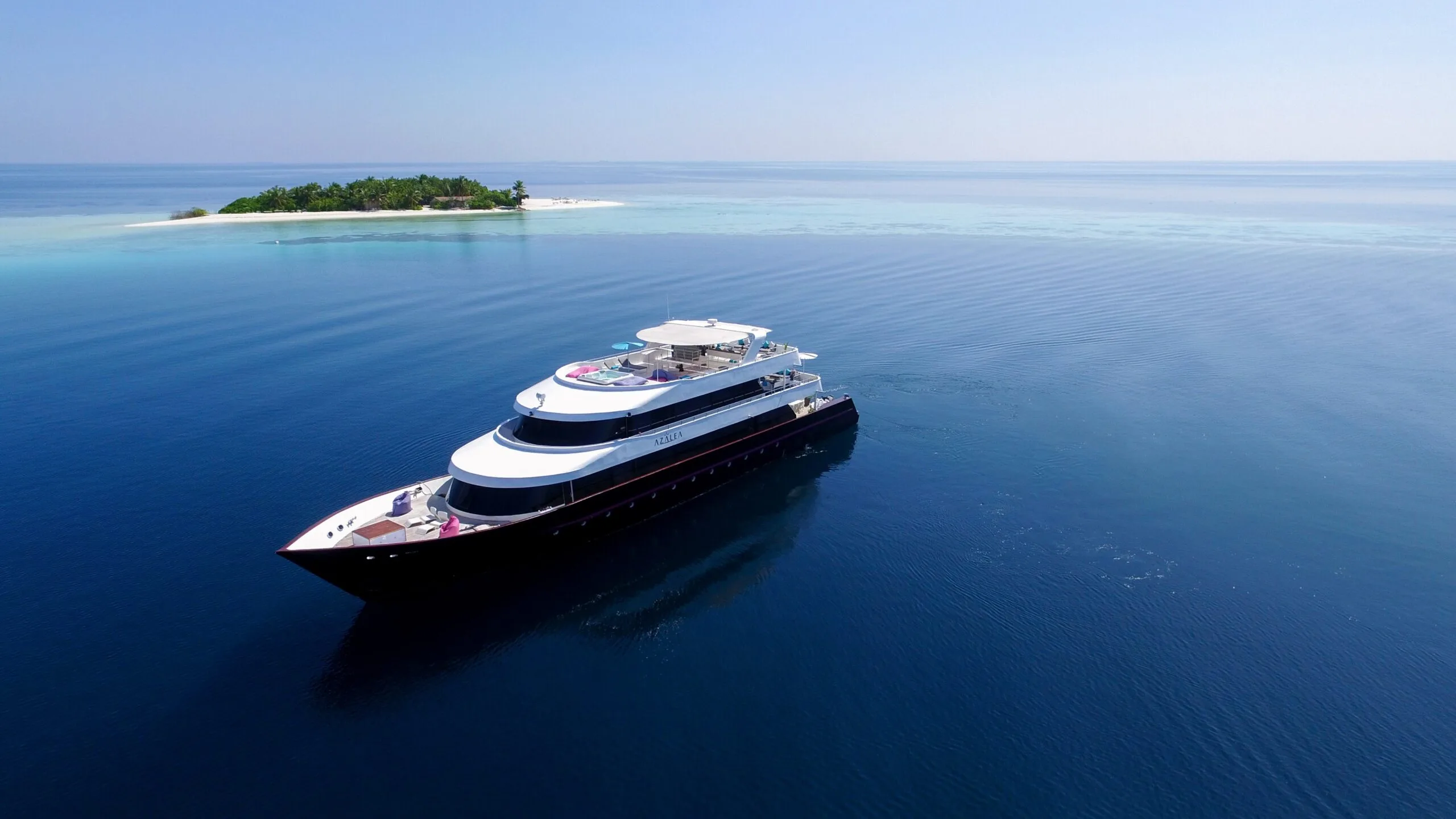 AZALEA yacht cruising near a small tropical island in the Maldives
