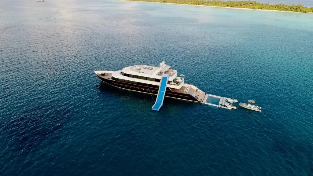 Aerial view of AZALEA yacht with waterslide and swim platform in the Maldives.